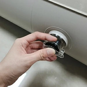 Hand operating the air valve on the inflatable air mattress.