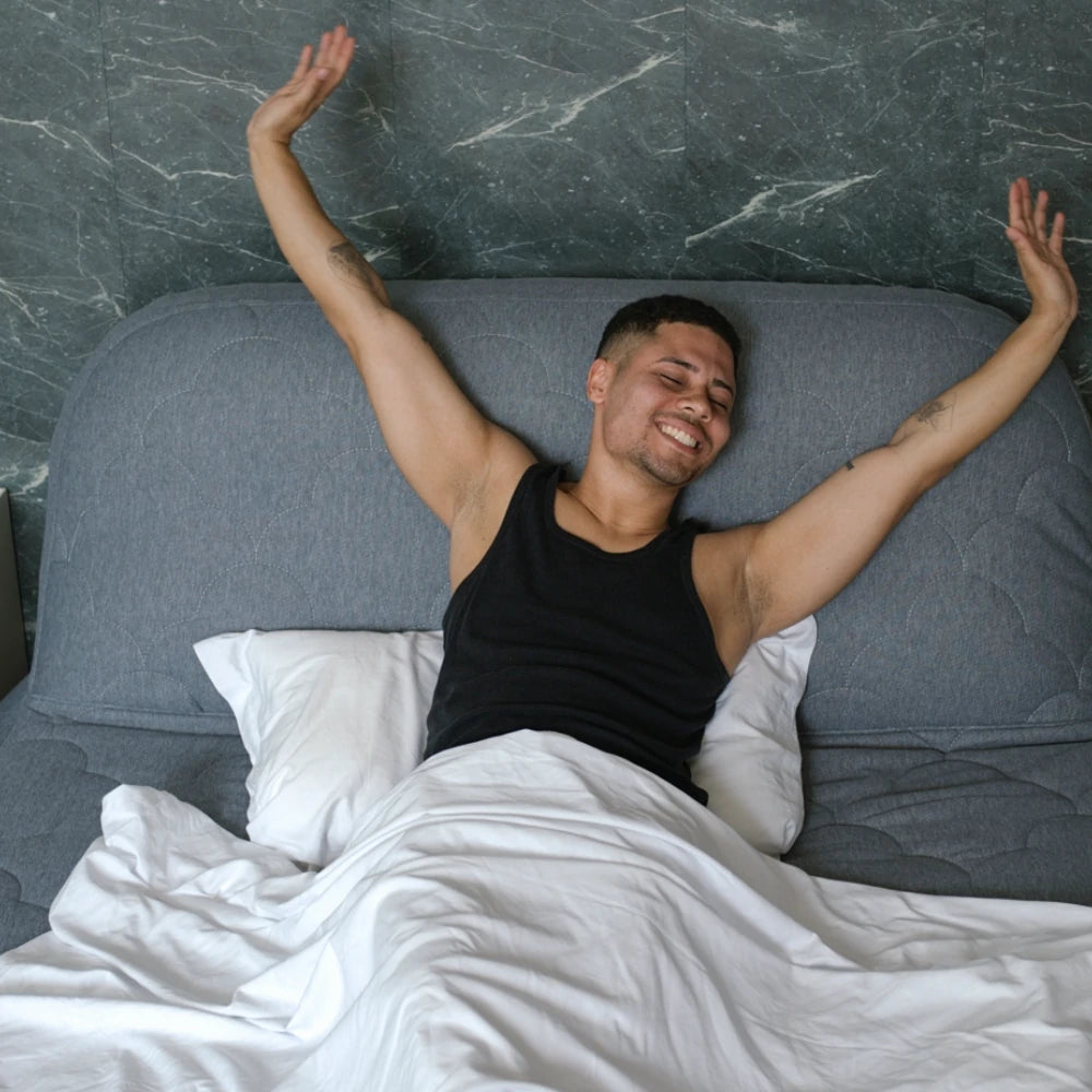 A man stretching happily on the Halrove Queen Size Inflatable Mattress, indicating a restful and comfortable sleep.