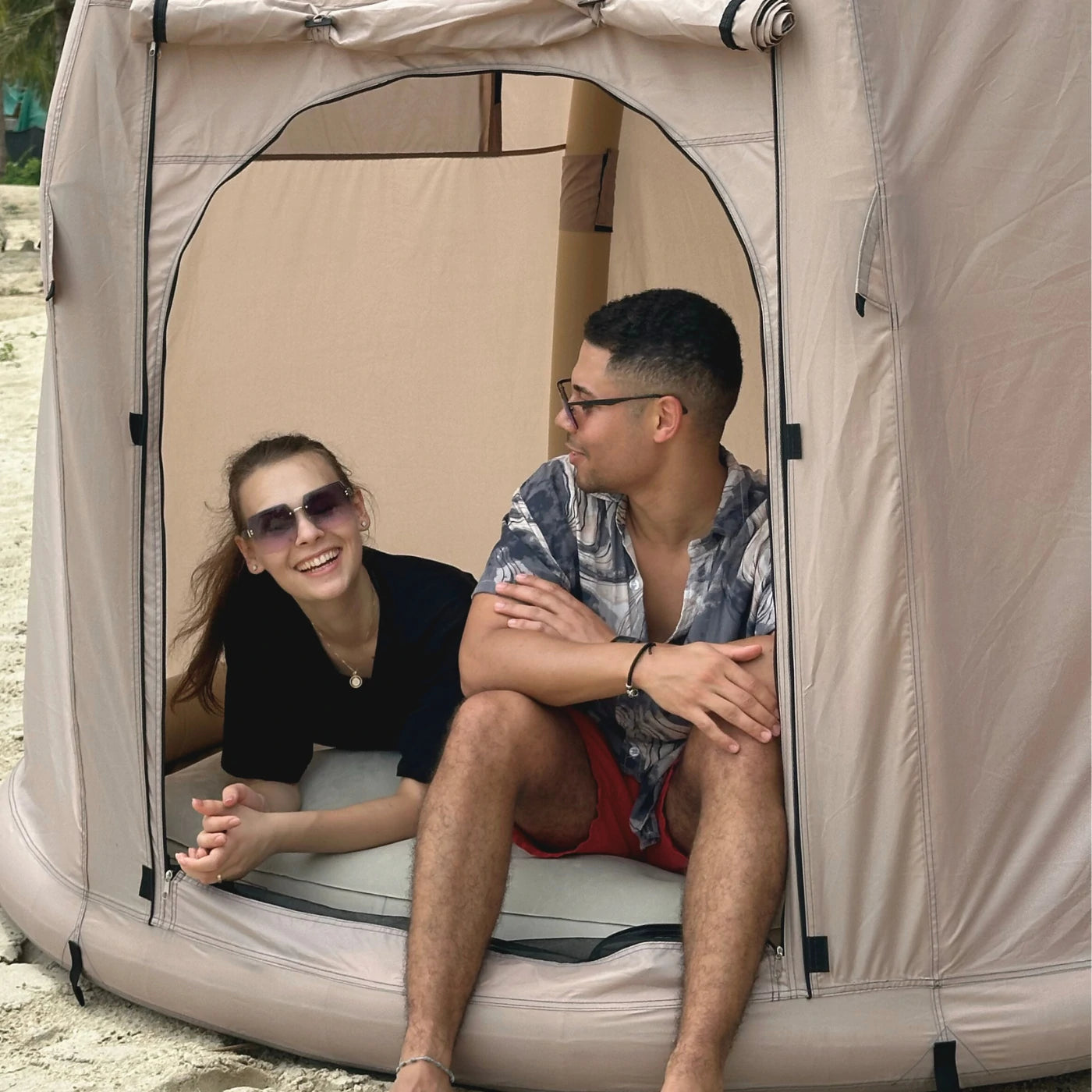 Couple enjoying Halrove inflatable camping tent on the beach, providing portable and comfortable shelter. 