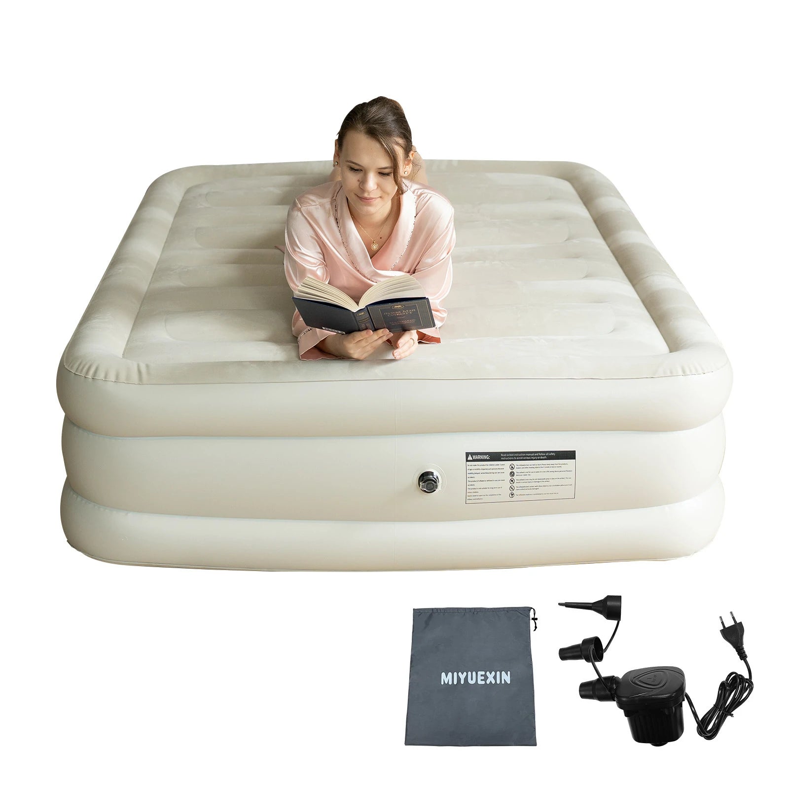 Woman sitting on a queen size inflatable air mattress, demonstrating its comfort and suitability for guests.