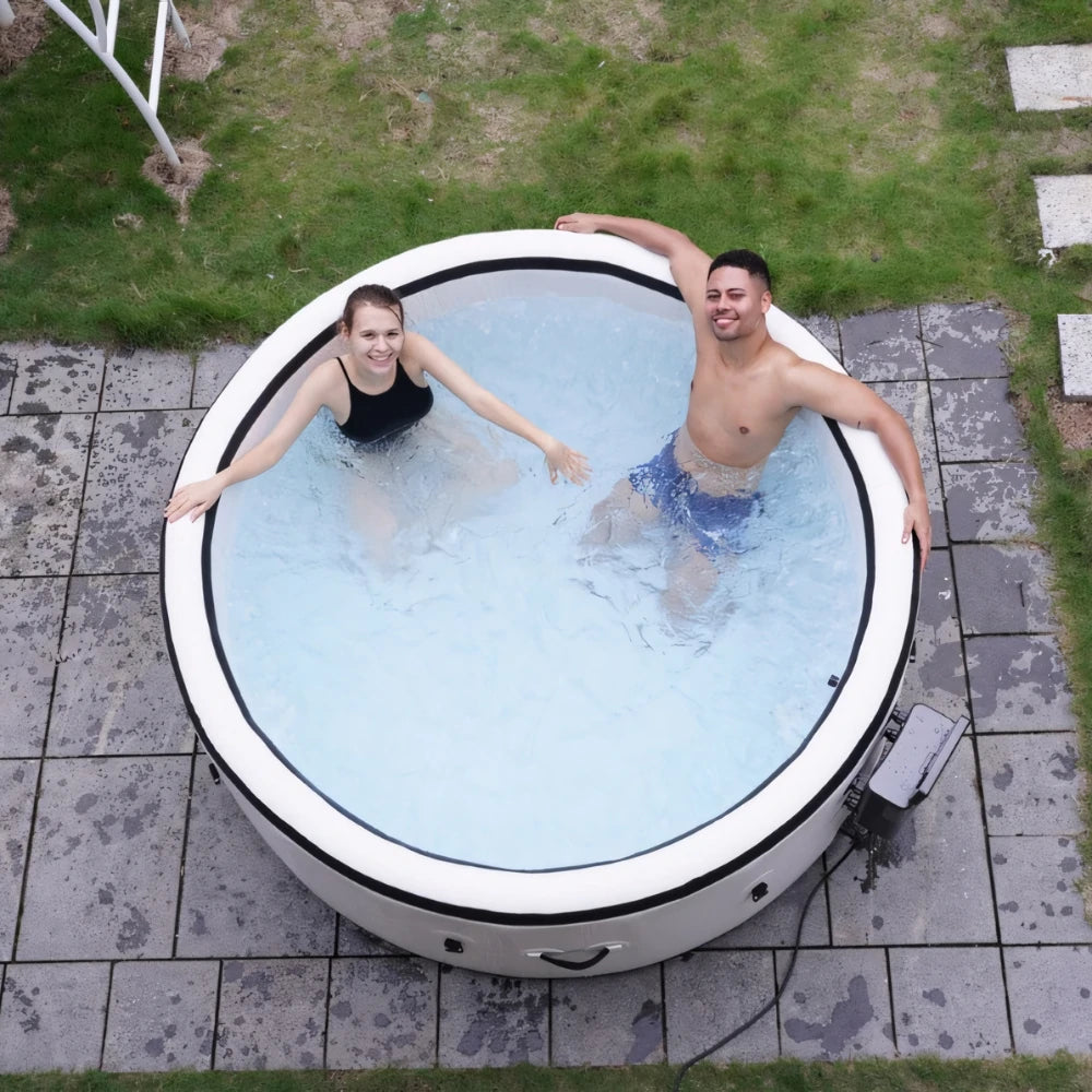 Two people enjoying their time in an inflatable hot tub placed on a patio, demonstrating its spaciousness and comfort.